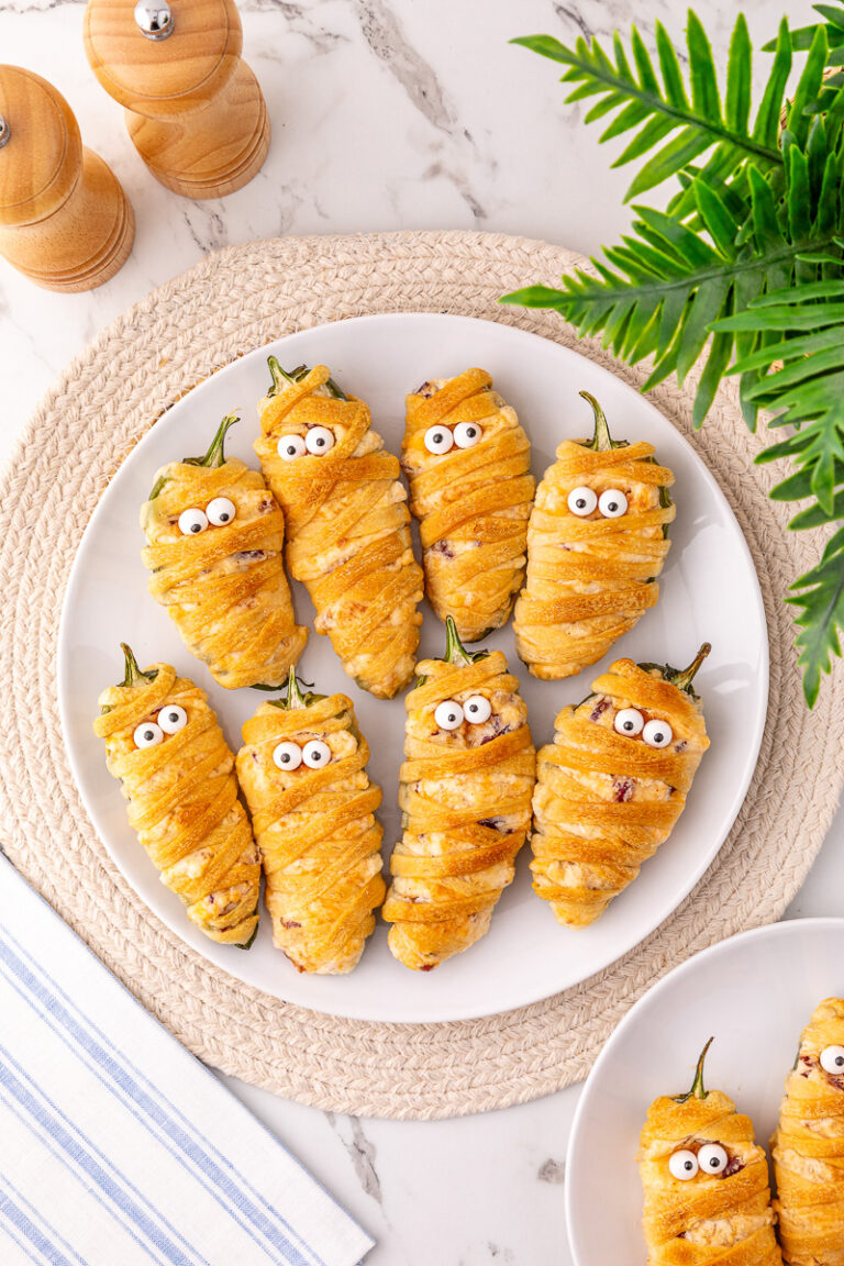 Jalapeno popper mummies on a white plate.
