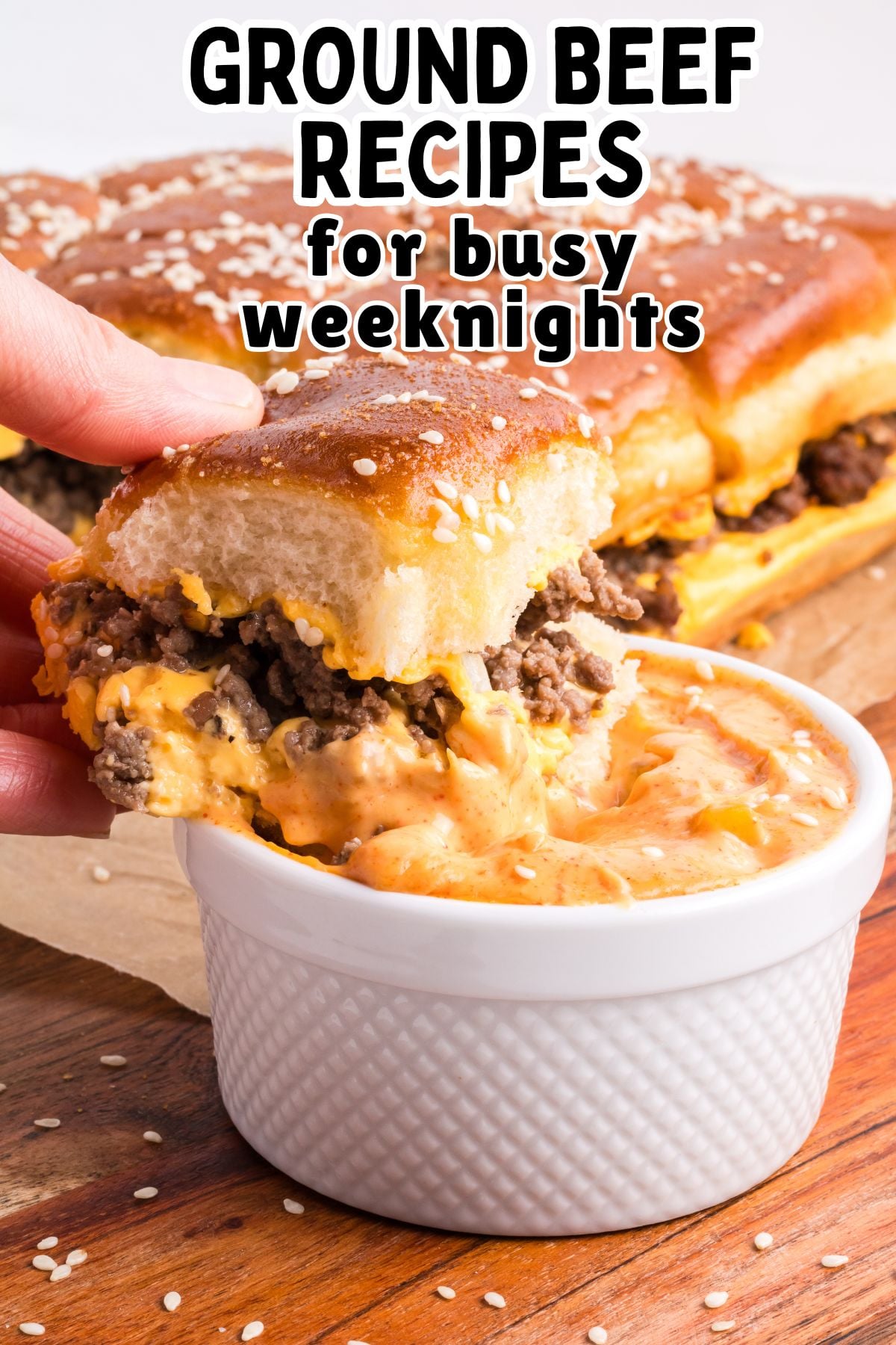 Cheeseburger sliders are dipped into special sauce.