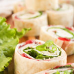 Cranberry turkey pinwheels on a wooden board.
