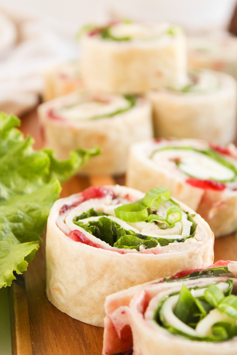 Cranberry turkey pinwheels on a wooden board.