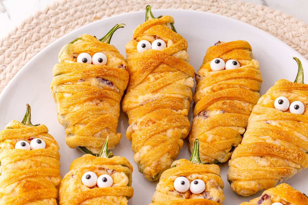Jalapeno popper mummies served on a plate.
