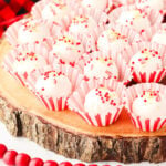 Peppermint cream cheese truffles on a wooden board.