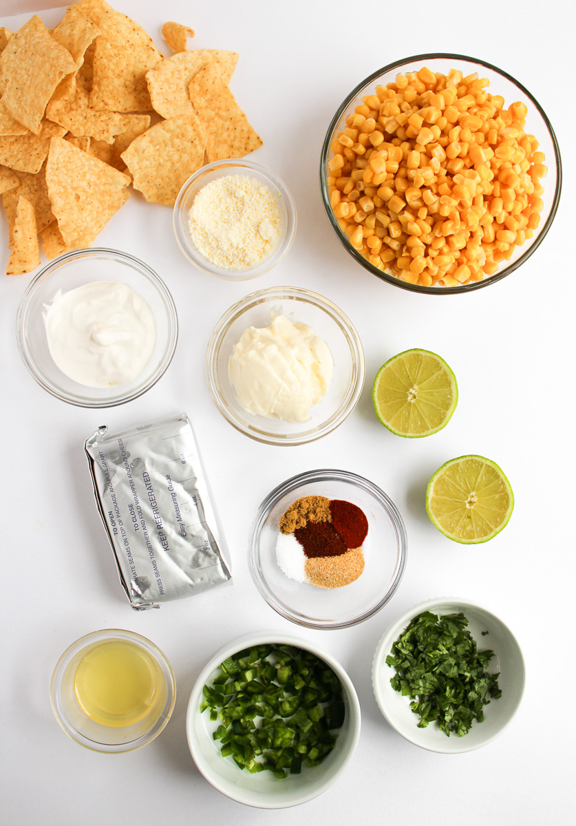 Mexican street corn dip ingredients in small bowls on counter.