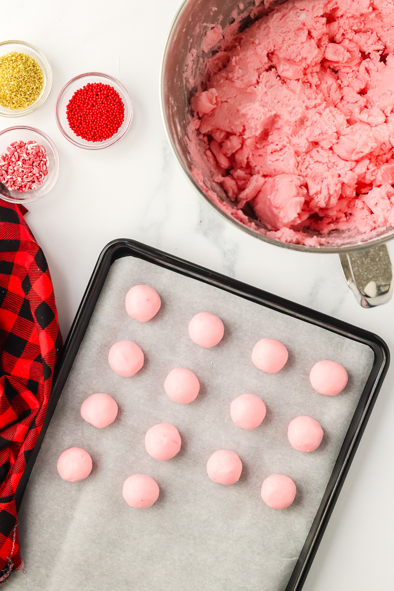 Shaped balls on parchment lined baking sheet.