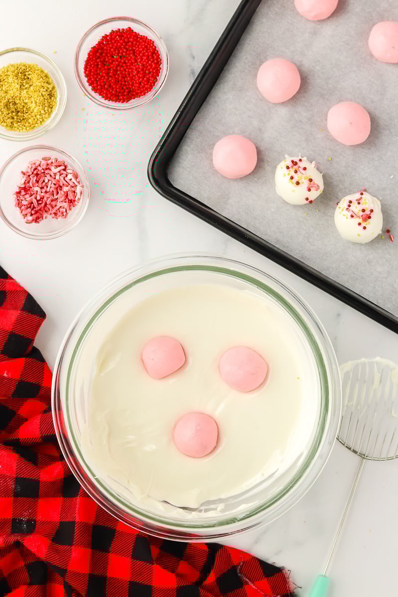 Chilled truffled balls are dipped into melted white chocolate.