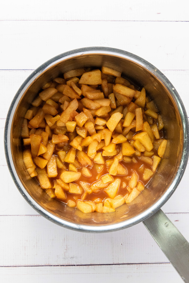 Cooked apple pie filling in saucepan.