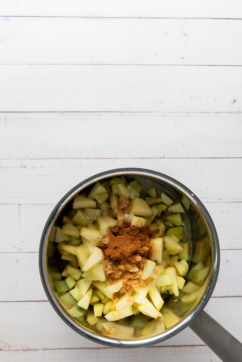 Apples and spices in saucepan.