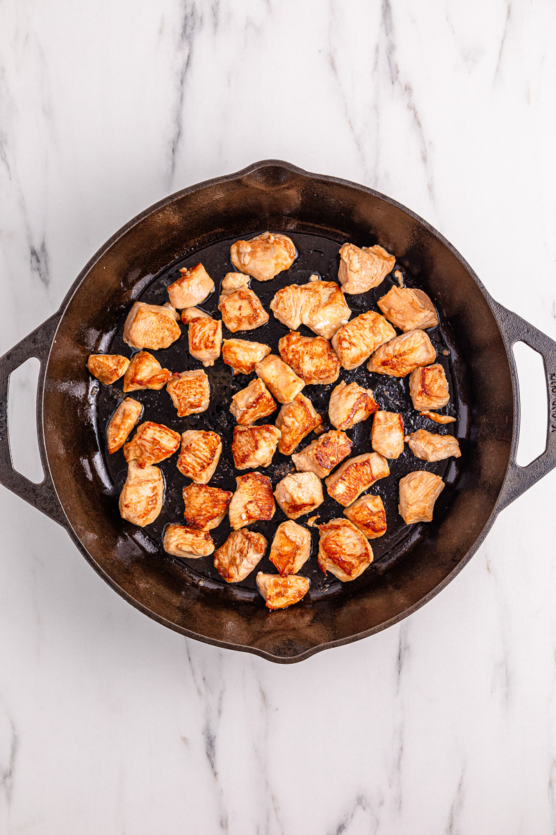 Chicken in skillet with oil.