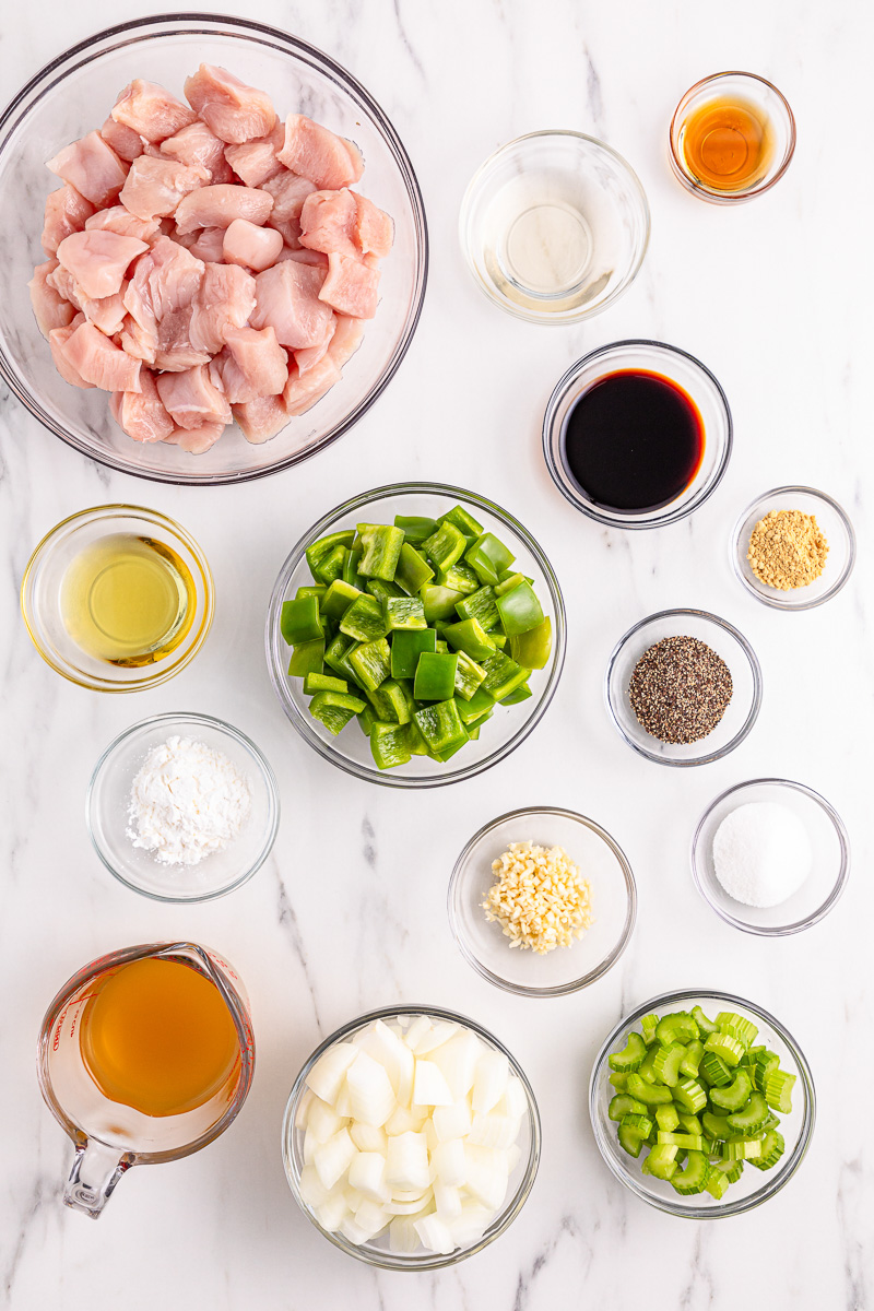 Ingredients for black pepper chicken in small bowls on counter.
