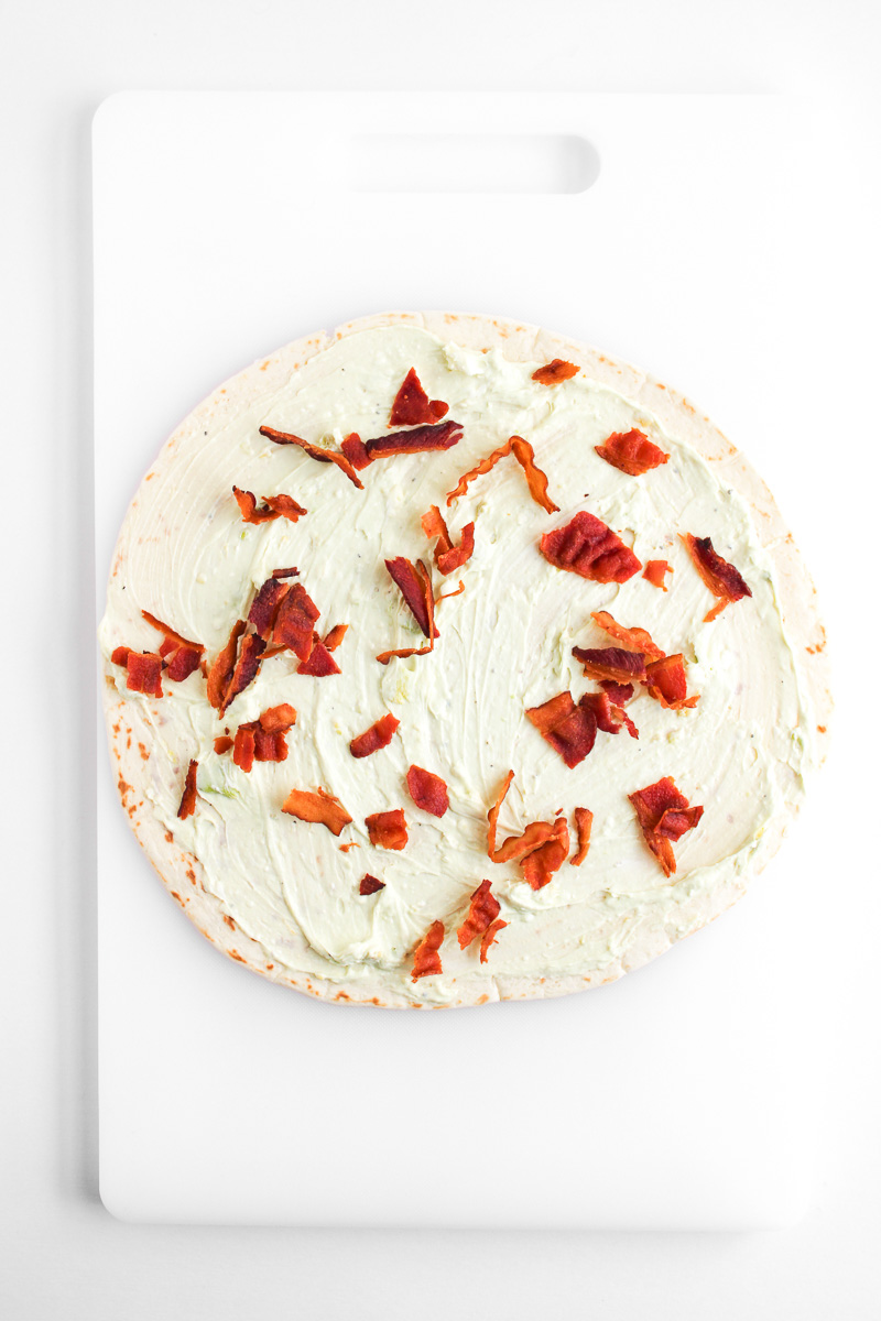 Bacon is sprinkled on top of cream cheese mixture.