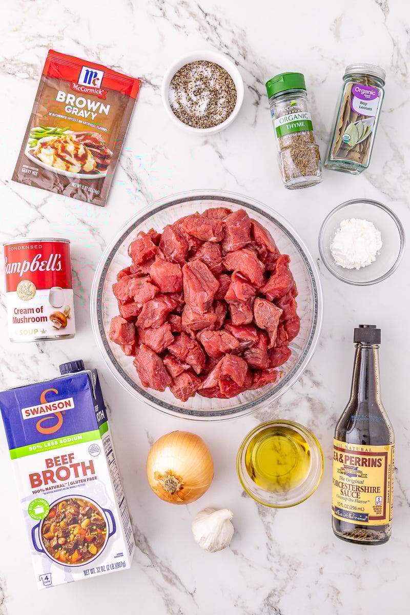 Ingredients for slow cooker beef tips and gravy in small bowls on counter.