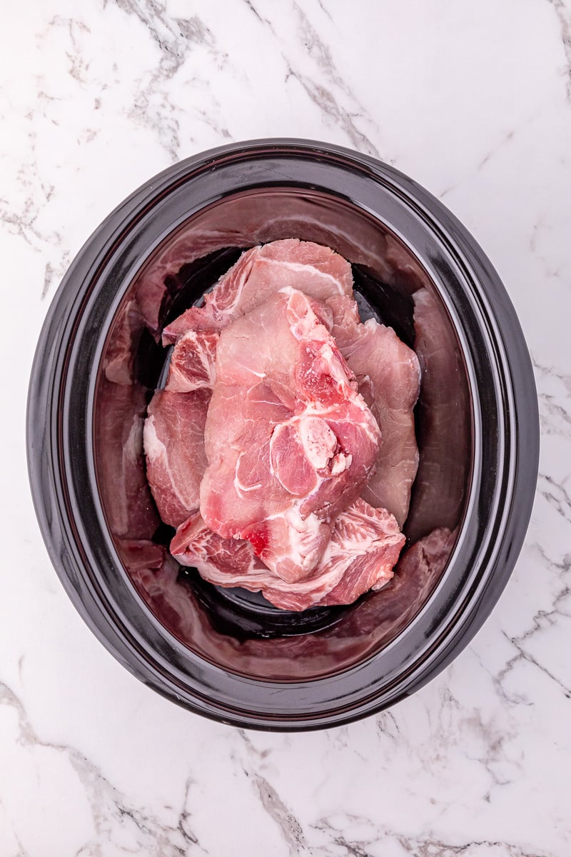 Pork chops are placed in the bottom of crockpot.