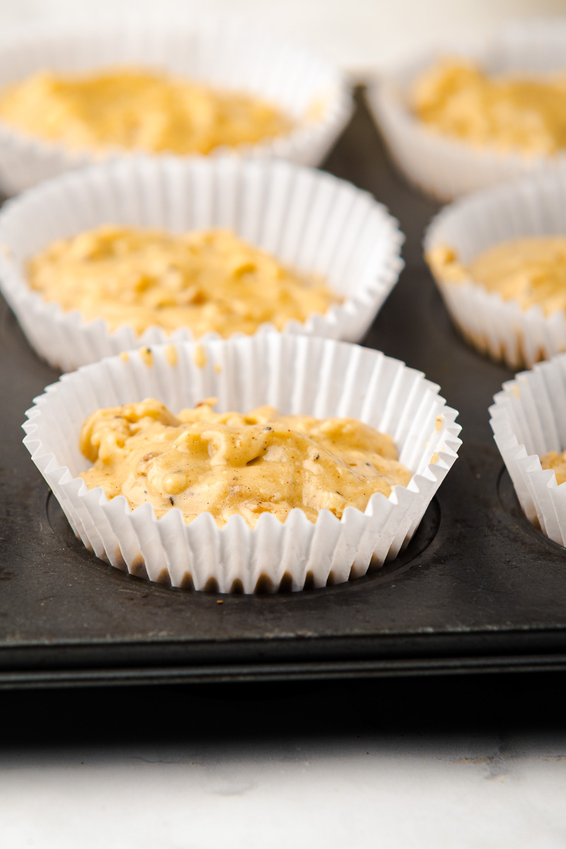 Muffin cups are filled 3/4 full and ready to bake.