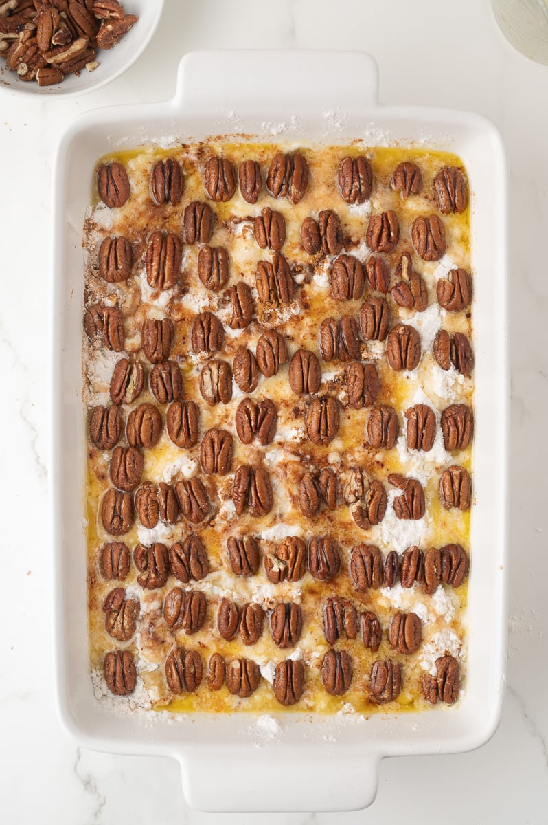 Remaining pecan halves are placed on top of the cake.