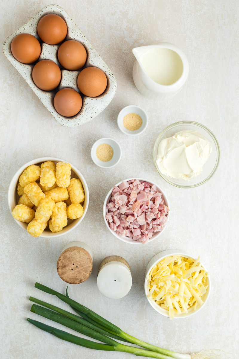 Ingredients for breakfast casserole with tater tots in small bowl on kitchen counter.