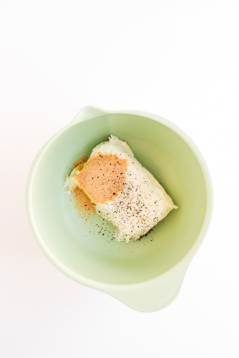 Cream cheese and seasoning in bowl.