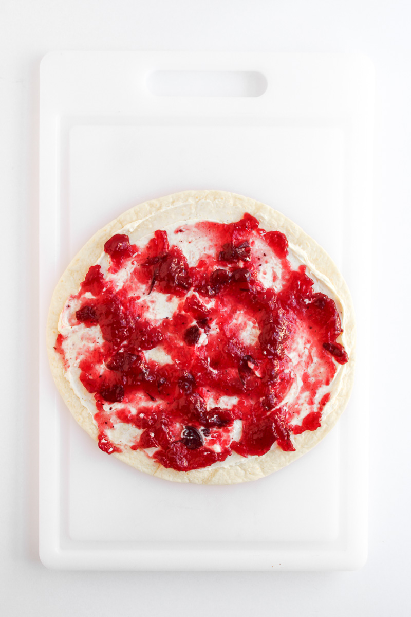 Cranberry sauce is spread on top of the cream cheese mixture.