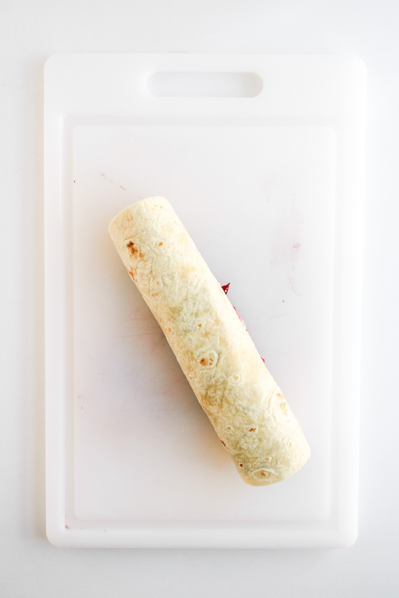 Tortilla is rolled up and ready to be placed in the fridge.