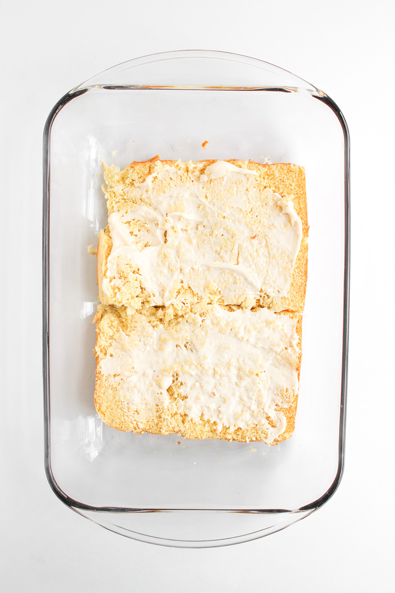 Mayonnaise is spread on bottom half of the Hawaiian rolls.