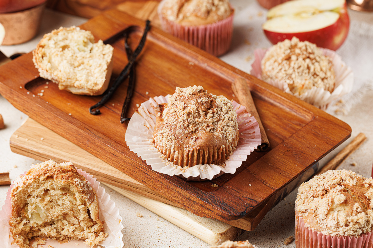 Apple cinnamon muffins on a wooden board.
