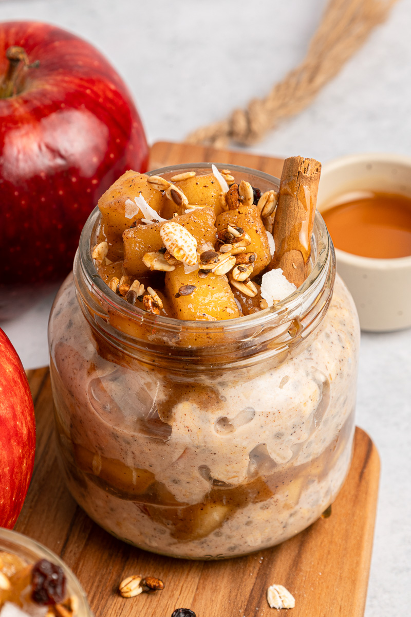 Apple pie overnight oats in glass jar ready to be eaten.