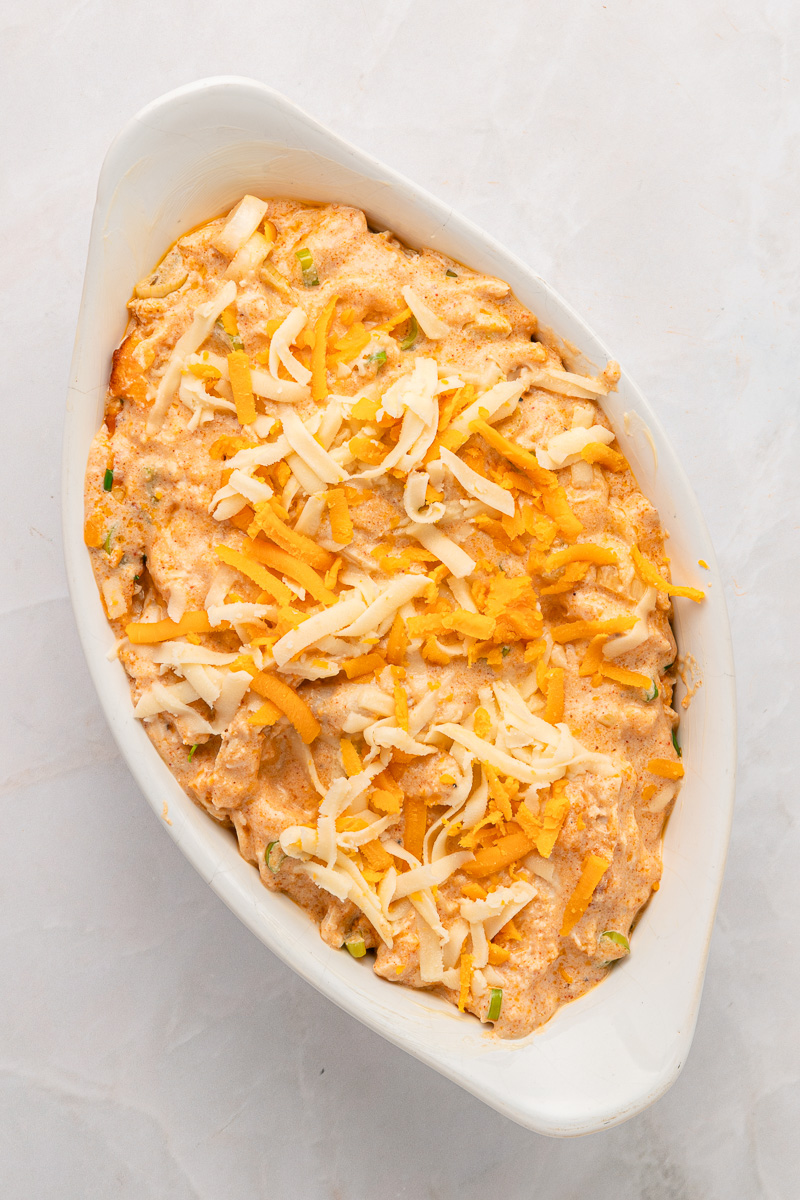 Chicken and cheese mixture is spread in baking dish.