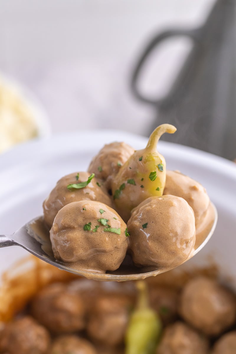 Close up image of crockpot Mississippi meatballs on spoon.
