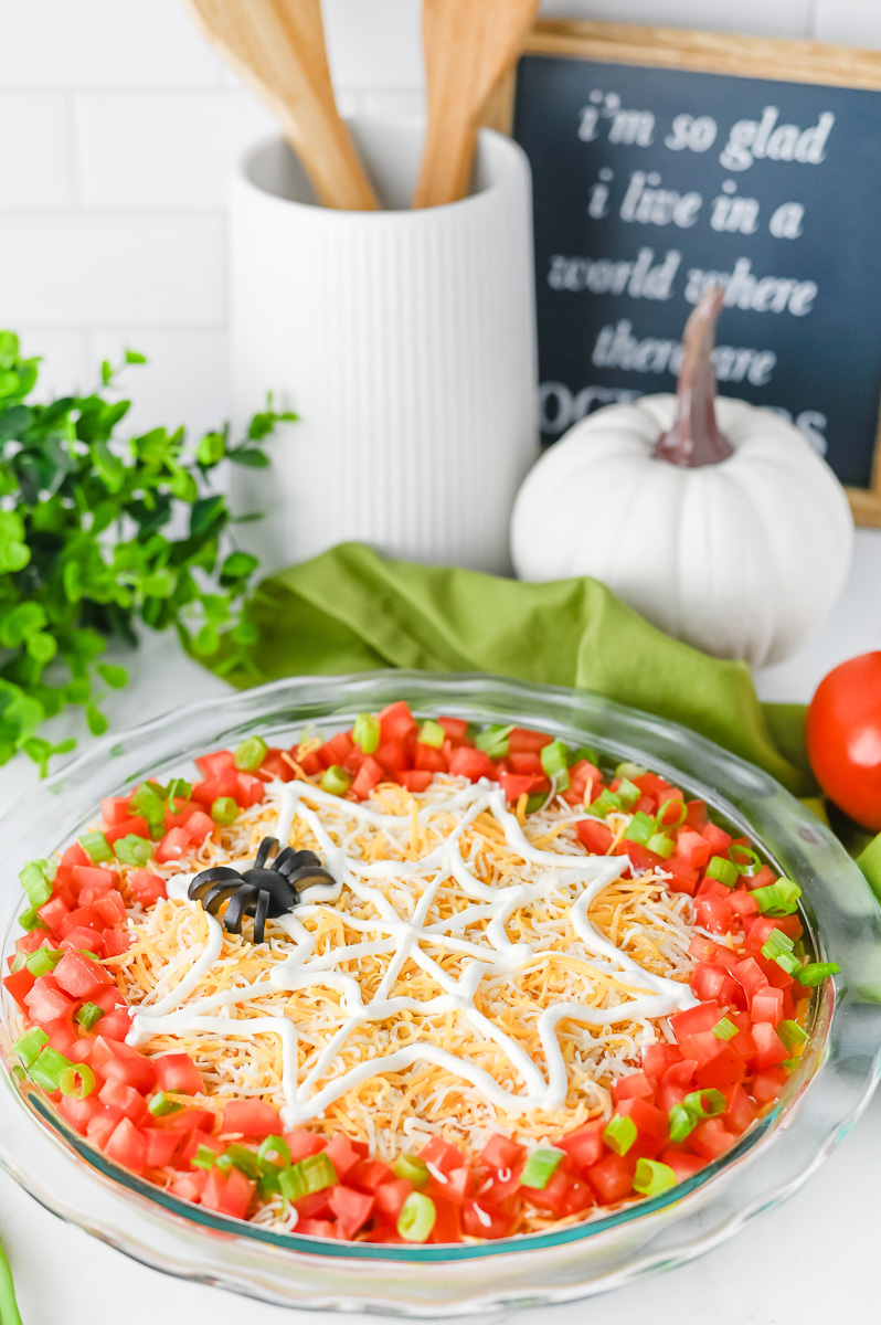Halloween taco dip in pie plate with tacos on the side.