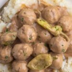 Crockpot Mississippi meatballs on a plate with mashed potatoes.