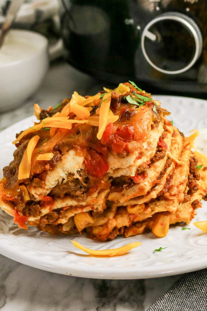 Crockpot taco casserole served on a white plate.