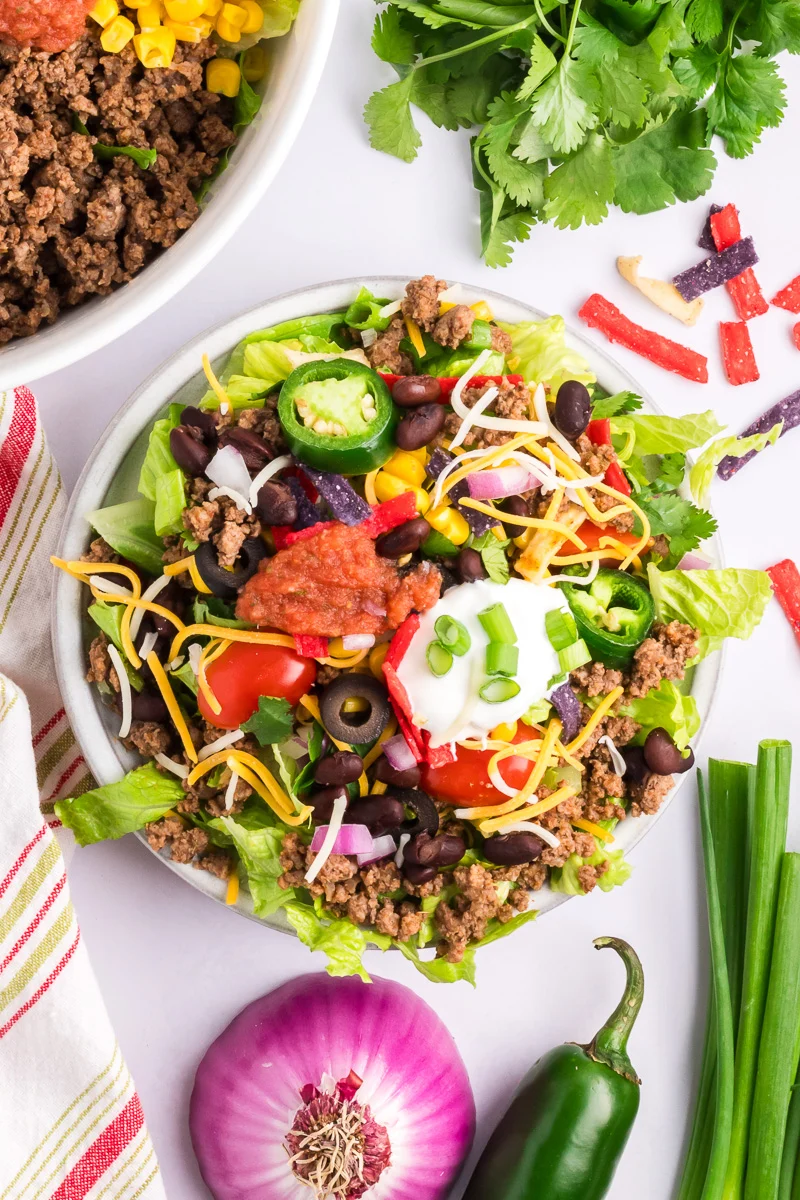 Overhead view of ground beef taco salad in a white bowl.