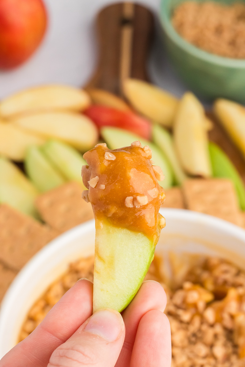 Caramel apple dip scooped up with an apple.