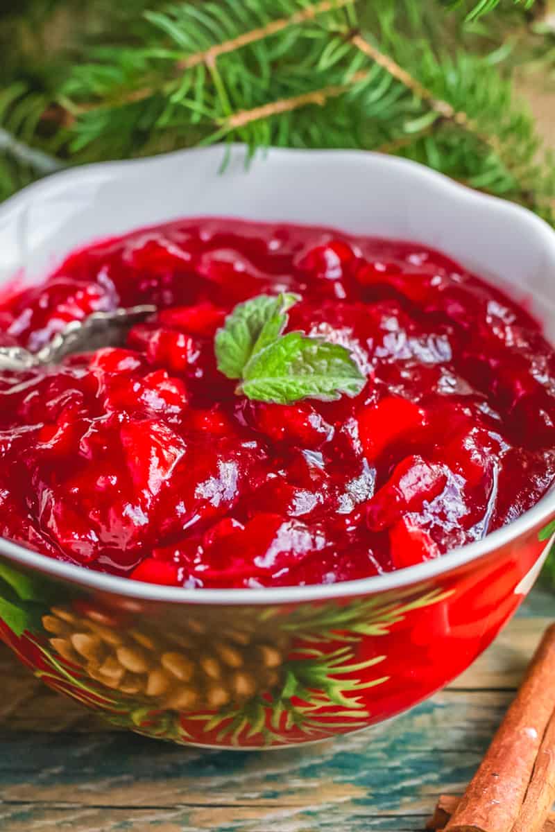 Cranberry sauce served in a bowl with mint leaf garnish.
