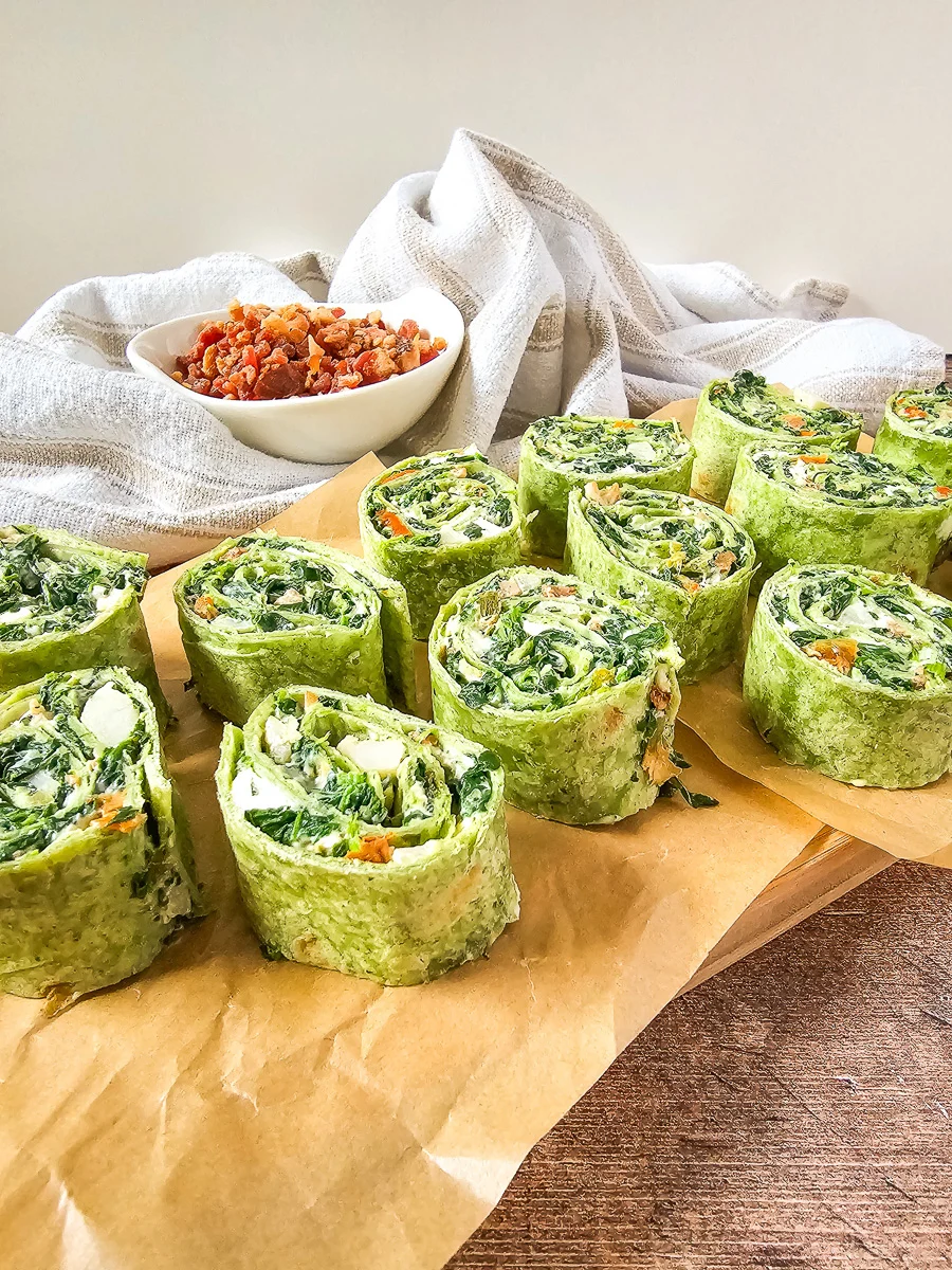 Spinach dip pinwheels on parchment paper, ready to be served.