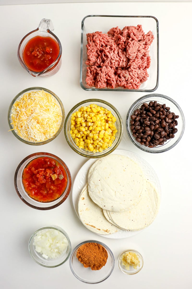 Ingredients for crockpot taco casserole in small bowls prepared for this recipe.