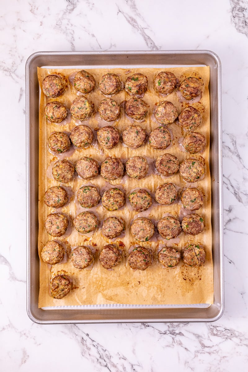 Cooked meatballs on baking sheet.