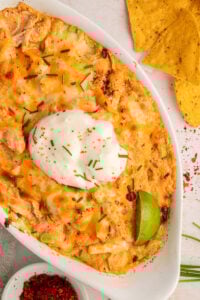 Overhead view of buffalo chicken dip with cream cheese in white baking dish.