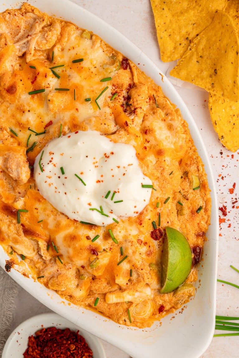 Overhead view of buffalo chicken dip with cream cheese in white baking dish.