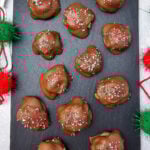 Caramel turtle pecan clusters on wooden board.