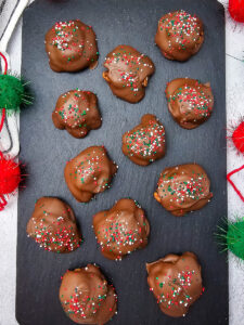 Caramel turtle pecan clusters on wooden board.