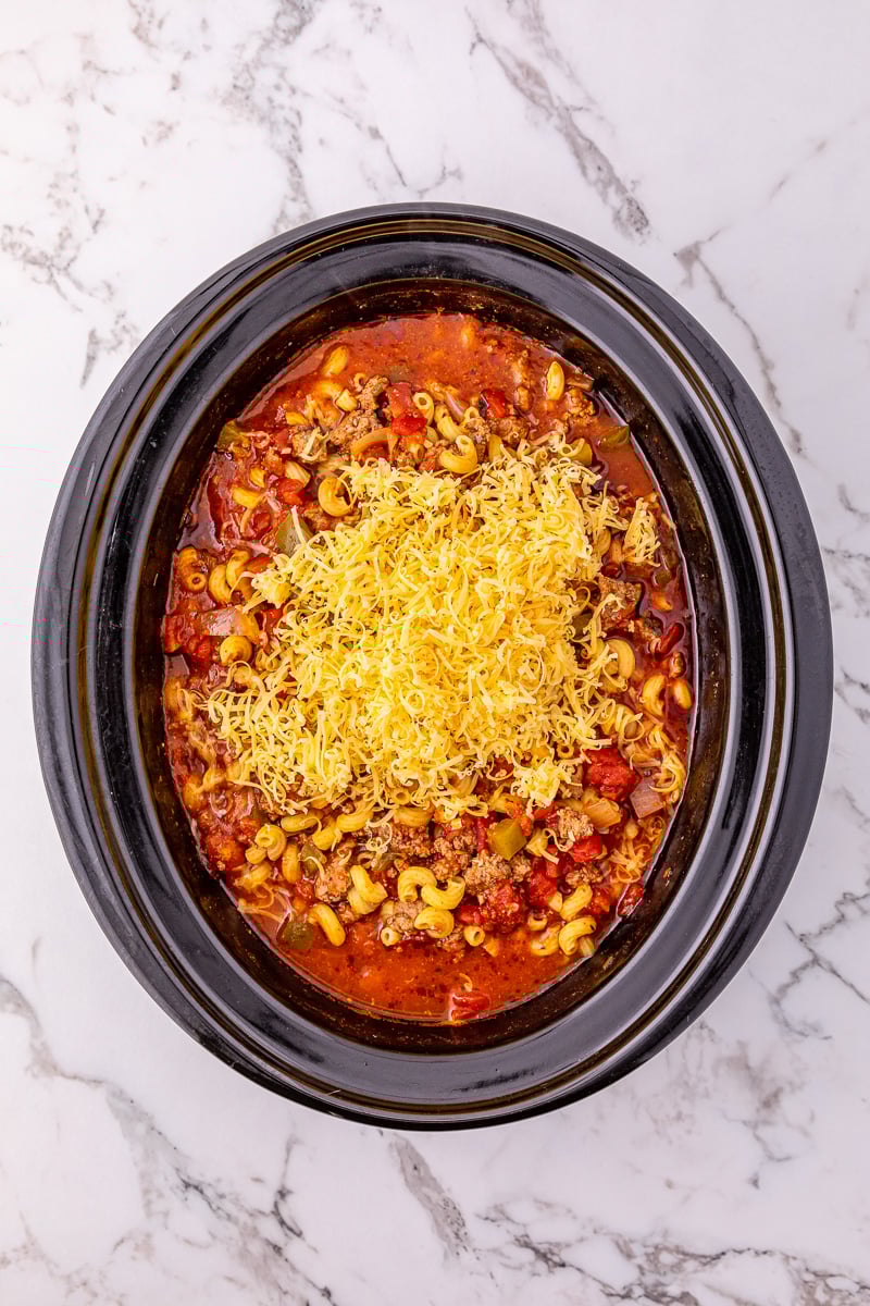 Shredded cheese is added to the crockpot.