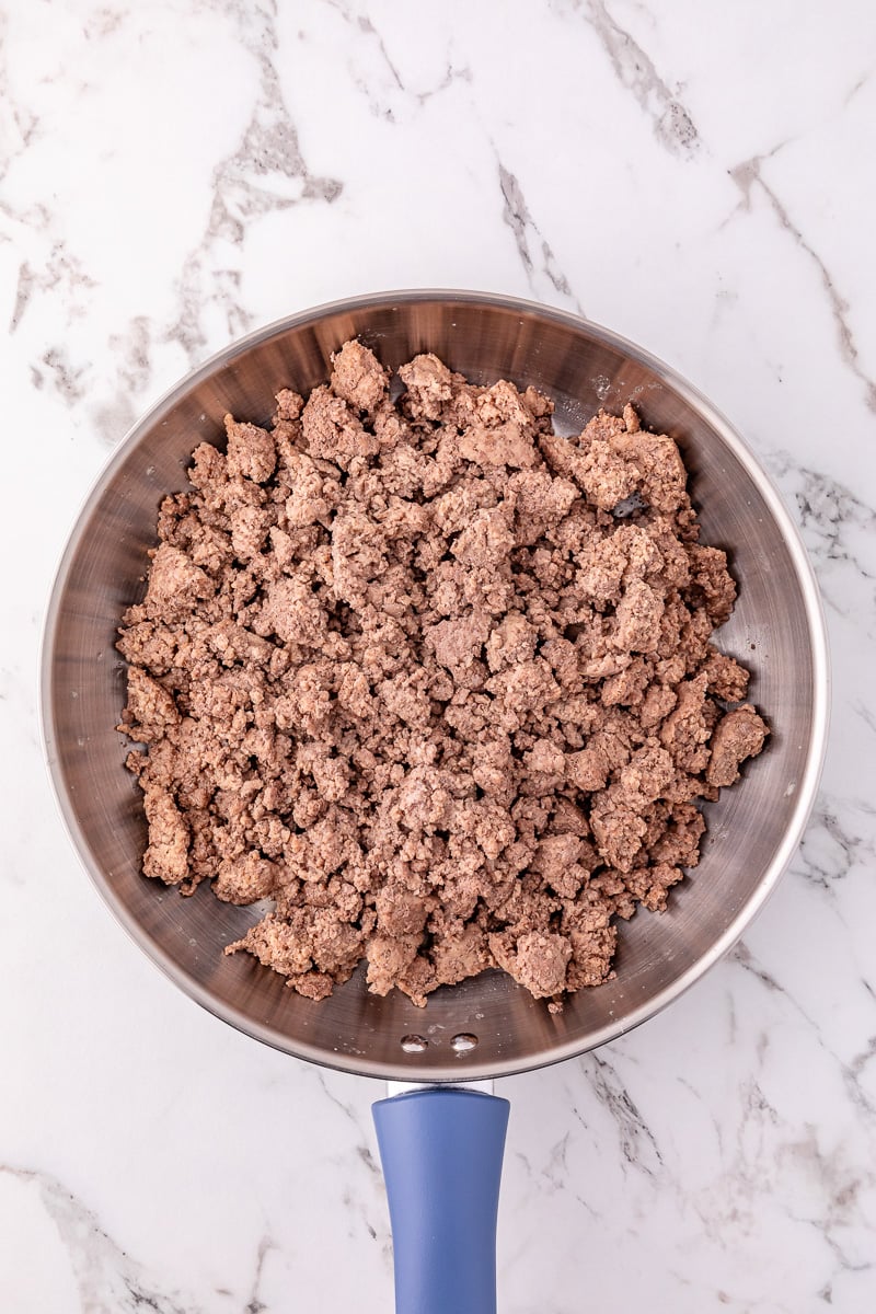 Cooked crumbled ground beef in skillet.