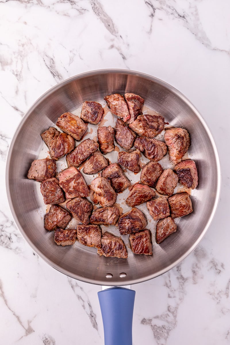 Steak bites are seared in skillet.