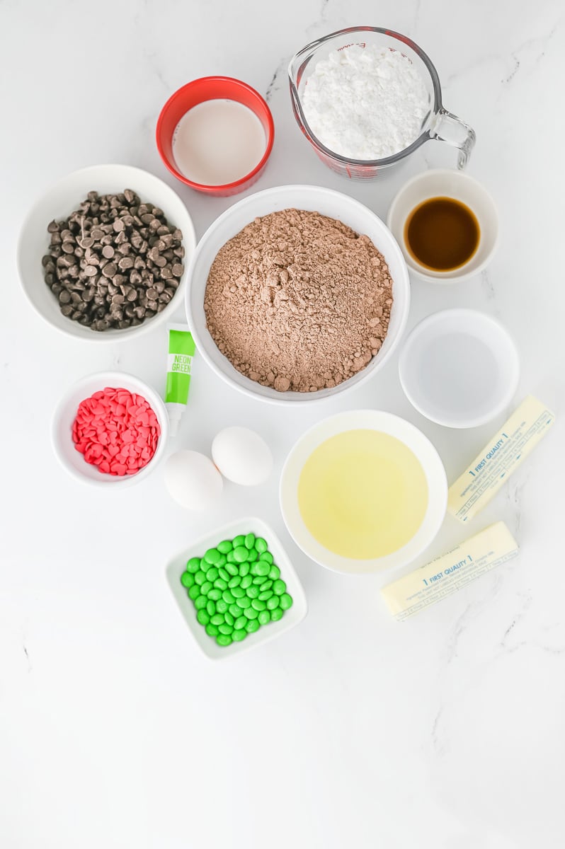 Ingredients for Grinch brownies in small bowls on counter prepared for recipe.