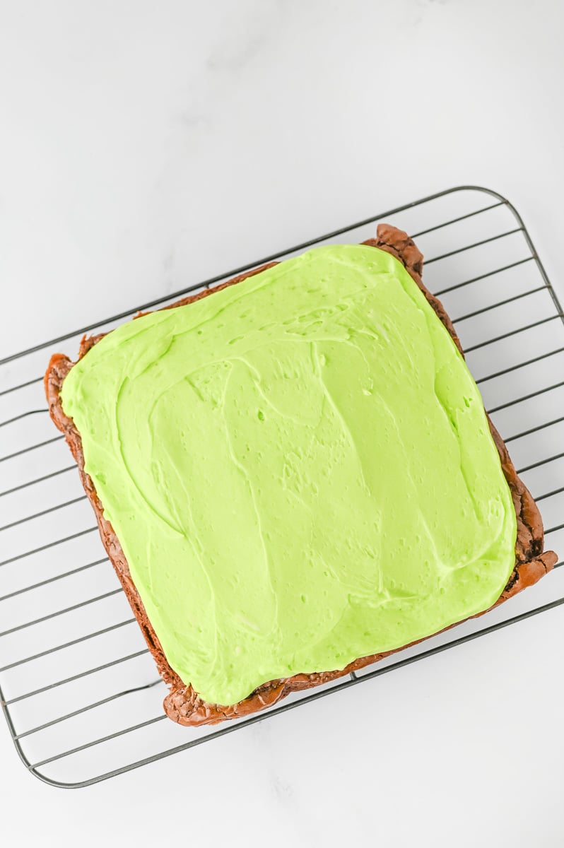 Green frostingis spread on top of brownies.