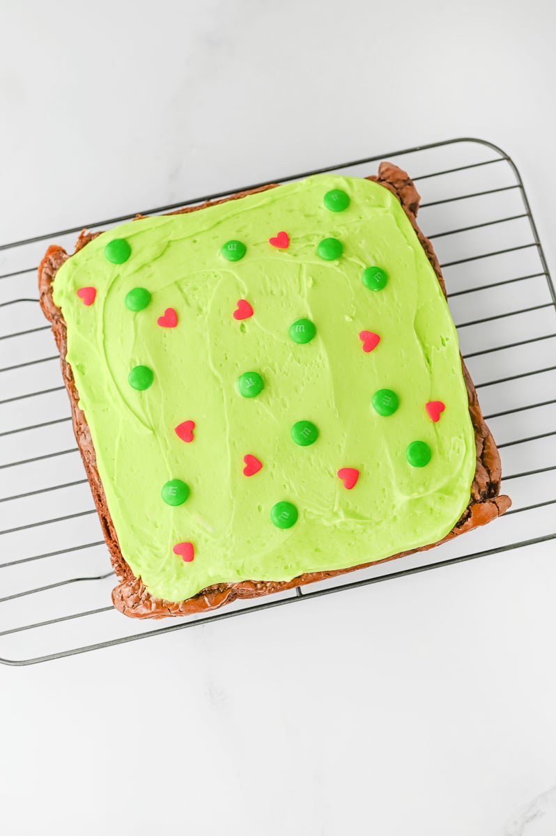 Frosted brownies are sprinkled with green M&M's and red candy hearts.