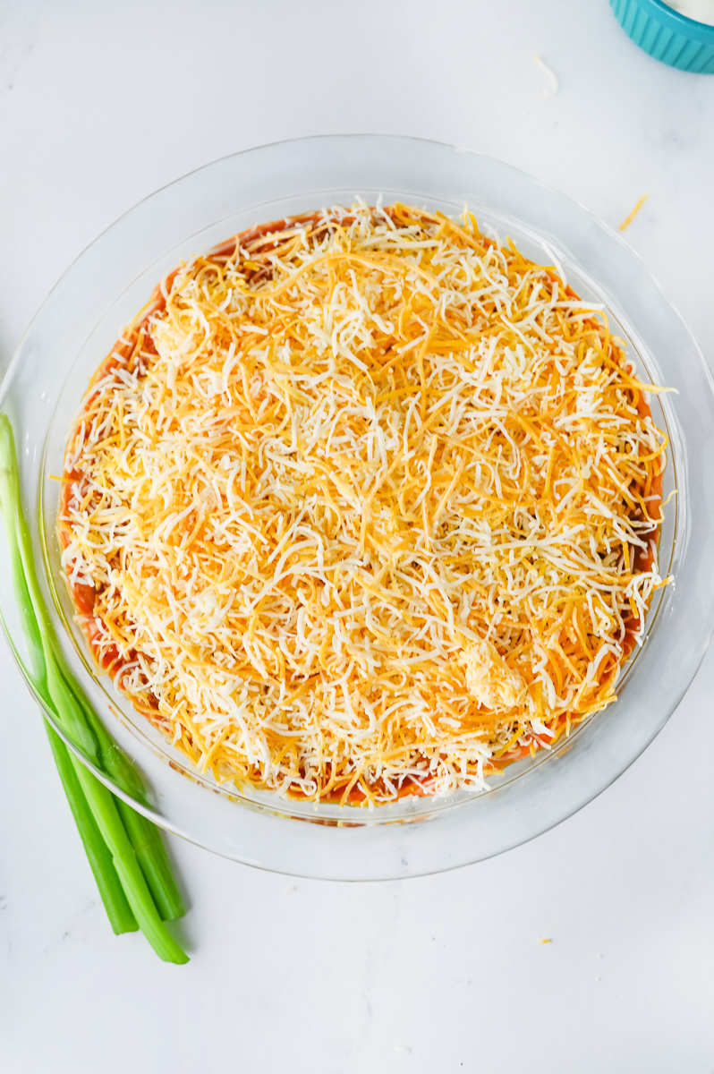 Shredded cheese is sprinkled on top of the salsa.