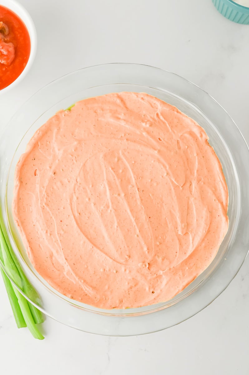 Sour cream that has been mixed with taco seasoning is layered on top of avocado.