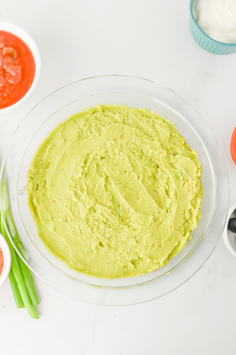 Guacamole is layered on top of the black bean layer.