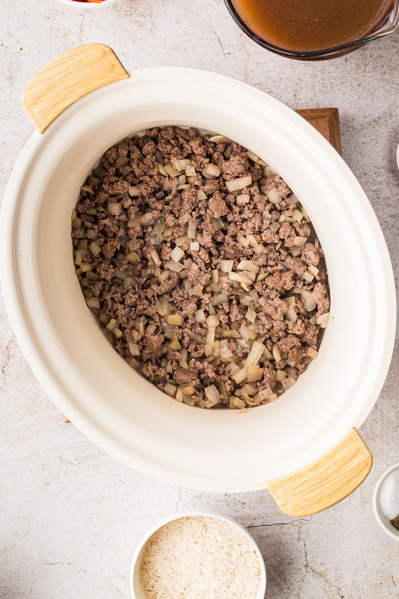Cooked ground beef mixture is transferred to slow cooker.